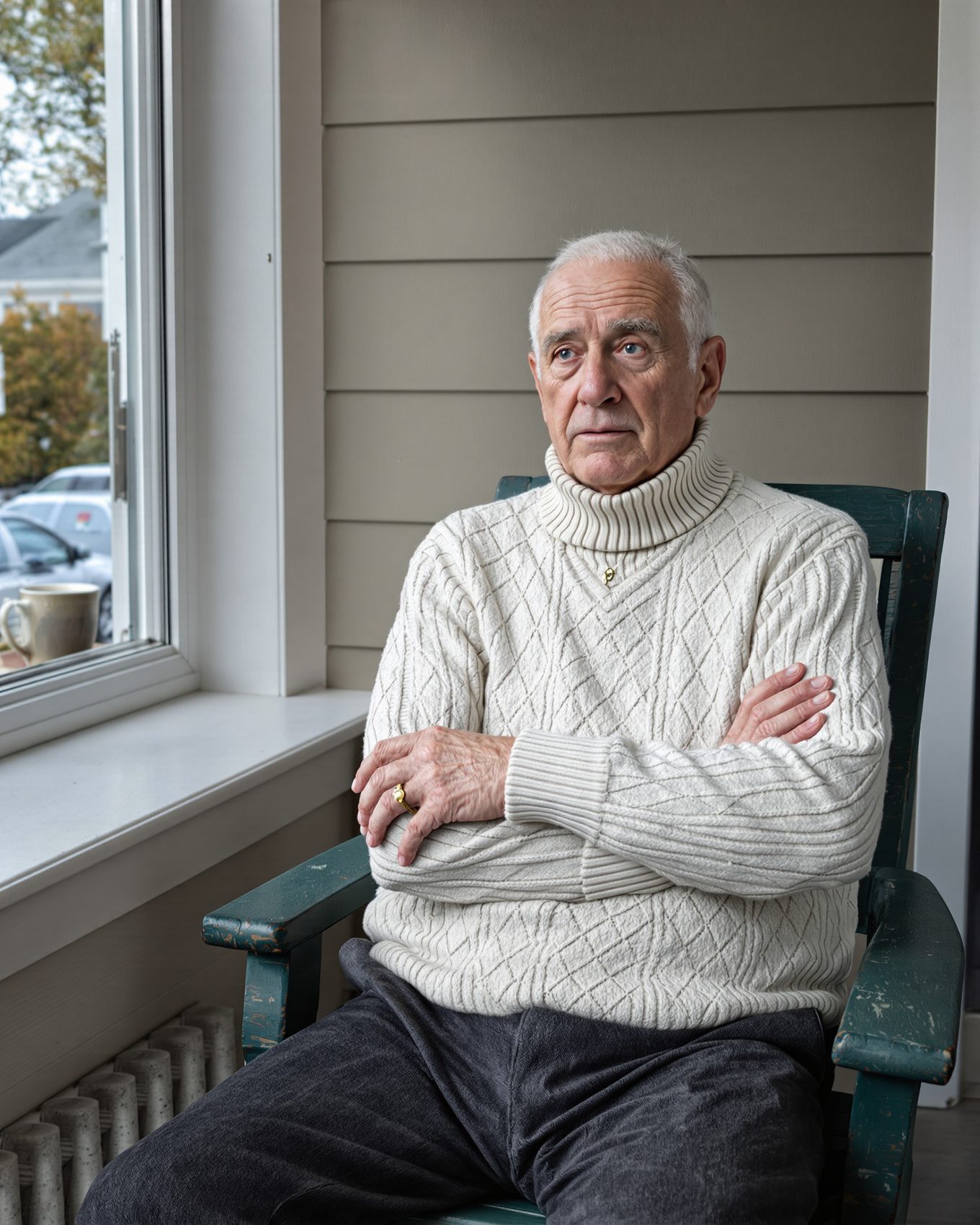 An older man alone on his front porch with a coffee mug.